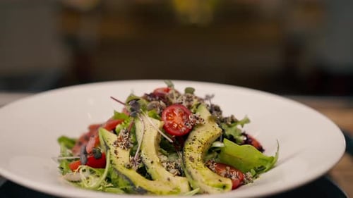 A close-up of a salad with avocado jamon and cherry tomatoes prepared in the professional kitchen