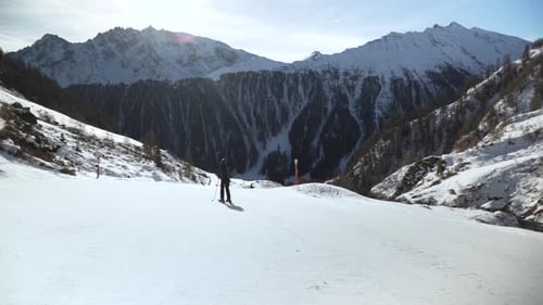 Skiers Enjoying Sunny Day in Snowy Mountains