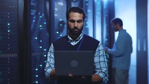 Data center engineers work on servers using laptop