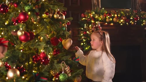 Merry Christmas Xmas Holiday Little Girl Decorating Christmas Tree on Christmas Eve at Home Young