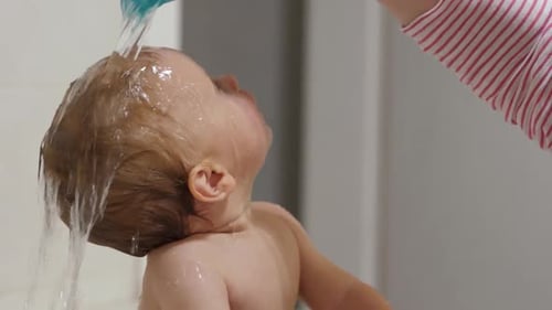 Baby Receives a Bath, Water Poured Over Hair
