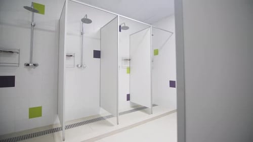 Public Shower Cabins with Chrome Heads in Gym Bathroom