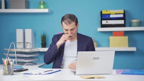 Unwell Man Working at Desk in Bright Office