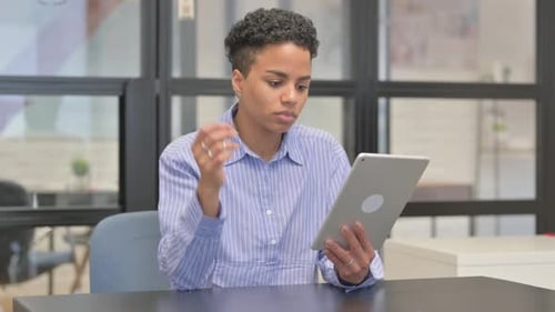 Woman Using Tablet at Table Indoors