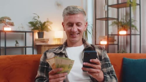 Smiling Happy Caucasian Man Counting Money Euro Cash Use Smartphone Income Salary Lottery Game Win