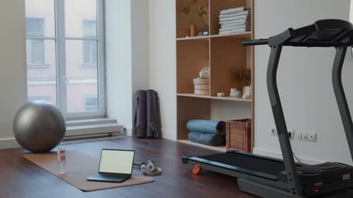 Home Gym Setup with Treadmill, Laptop on Mat and Exercise Ball