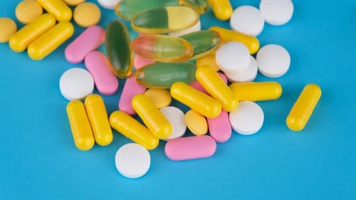 Colorful Pills and Capsules on Blue Background