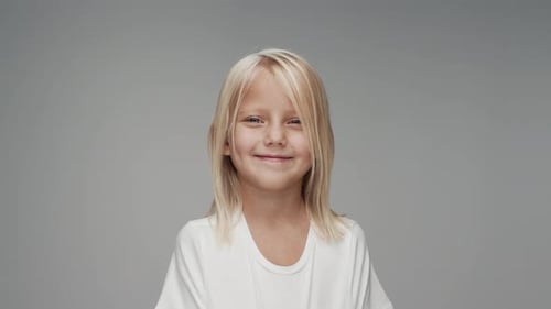 Studio Portrait of Young Caucasian Girl Looking at Camera and Smiling Happy
