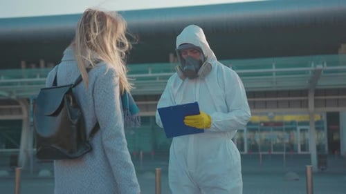 Health Worker Checks Woman's Temperature at Airport