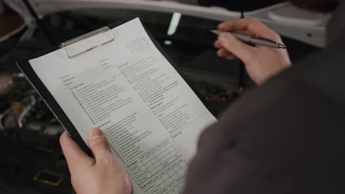 Der Techniker der Autowerkstatt schätzt die Reparaturkosten und erstellt die Rechnung