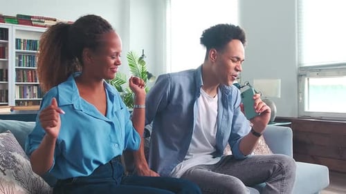 Couple Singing and Dancing to Music at Home