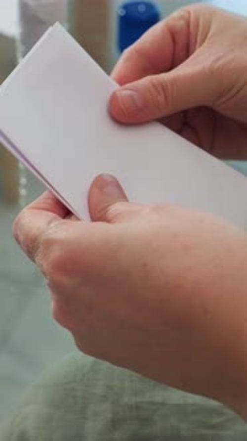 Steady Movements Forming Booklet on Glass Table Under Natural Light Meticulous Hand Movements