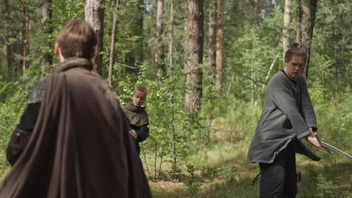Men Practice Sword Fighting in the Forest