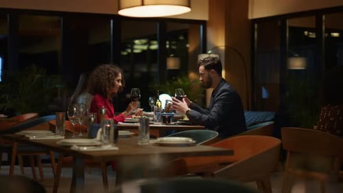 Elegant couple enjoying wine glass at romantic dinner date in luxury restaurant