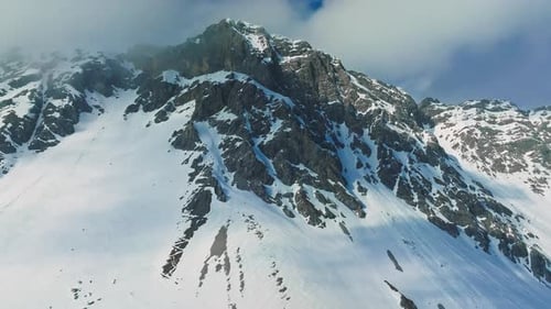 Alpenlandschaft mit schneebedeckten und wolkenbedeckten Gipfeln