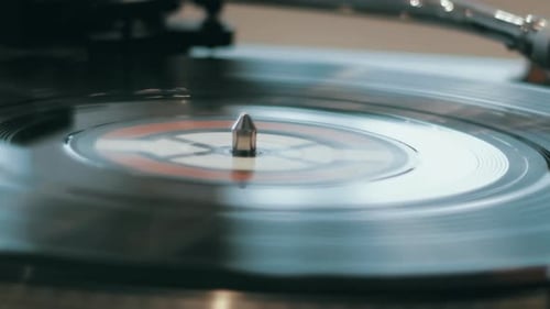 CloseUp View of a Vintage Record Player Needle on Vinyl Album in Warm Indoor Lighting