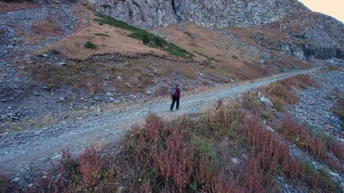 The Guy is Walking in the Mountains Along Gorge