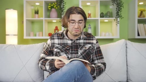 Man Reading Book on Couch in Living Room