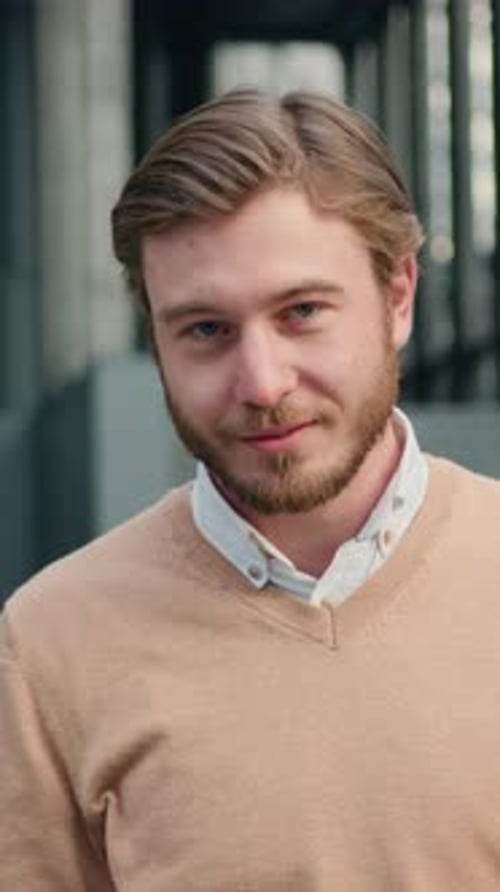 Closeup Portrait of Handsome Success Man Looking Up at Camera Smiling at Office Building Background