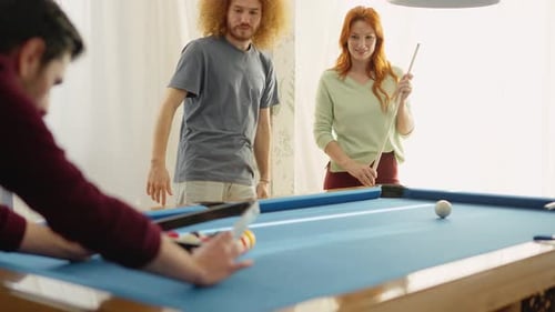 Group of Diverse Friends Playing Billiards in Apartment