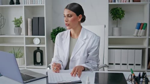 Remote Doctor Filling Form Talking at Online Consultation in Polyclinic Closeup