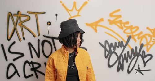 Expressive Woman Dancing in Front of Graffiti Wall