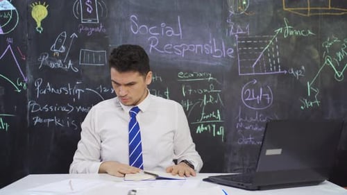 Businessman writes Social Responsibility on the board and folds his arms.