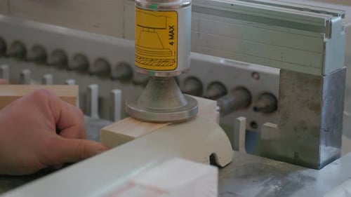 A man works with wood in a workshop. Working with wooden blanks. A man drills holes in wooden blanks