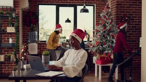 African American Coworkers Exchanging Gifts in Festive Decorated Office