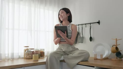 Joyful Morning, Woman with Tablet in Sunlit Kitchen