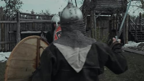 Two Warriors in Armoured Outfits Training with Swords and Shields in Fort