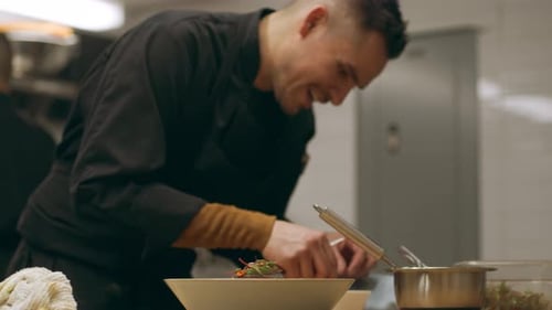 Chef Carefully Plating Dish with Fresh Herbs