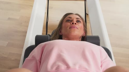 Woman Exercising on Pilates Reformer Machine