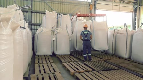 Worker Handling Large Bags in Warehouse Worker Handling Large Bags in an Industrial Warehouse The