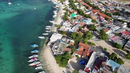Vibrant Aerial of Coastal Town with Boats Lining the Shoreline