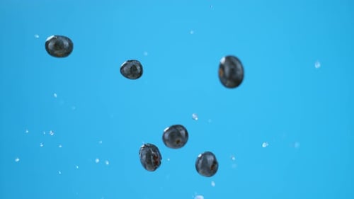 Six blueberries with water droplets launched in air, flying. High quality cinematic studio commercia