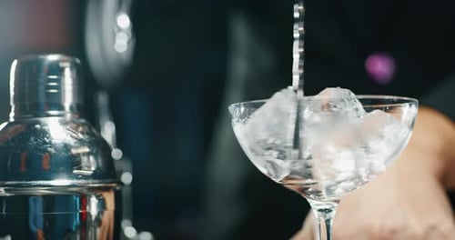 Close up of a professional bartender is preparing an alcoholic cocktail with professional crystal