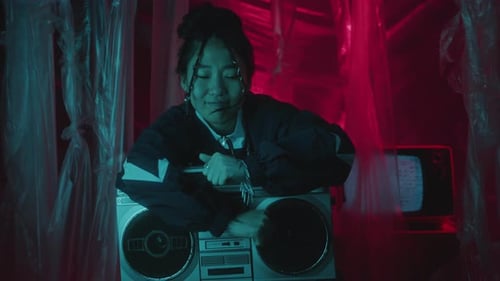 Vibey Asian Girl Dancing to Music on Boombox in Studio with Neon Light