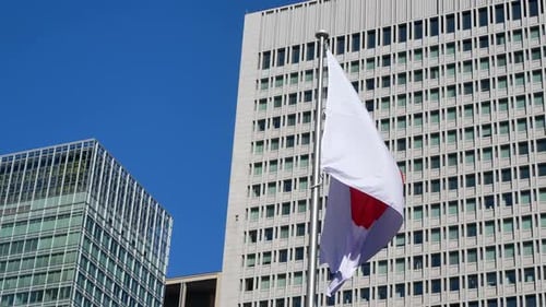 Japanese Flag Waving in Front of City Buildings