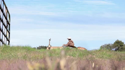 Rancher Driving Harrow Tractor Across a Field