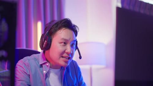 Man Playing Video Game Using Computer and Headset