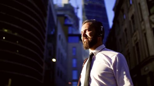 Hipster Businessman with Headphones Standing on the Street in London in The