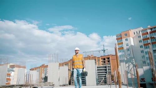 Construction Worker Walking on Building Site with Tools