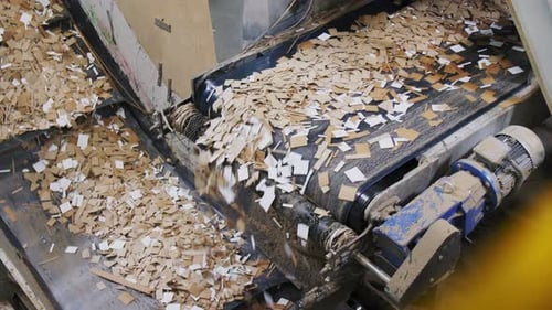 Altpapier fließt vom Förderband auf die Produktionslinie in der Anlage