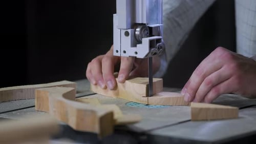 A man works with wood in a workshop. Working with wooden blanks. A man drills holes in wooden blanks