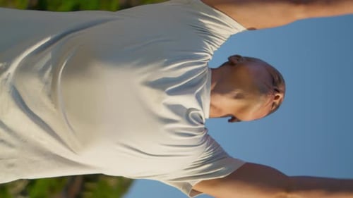 Bald Man Does Yoga Outside in the Daytime