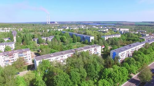 Beautiful sunny day panorama of a residential city area. Blue river and farmlands at backdrop.
