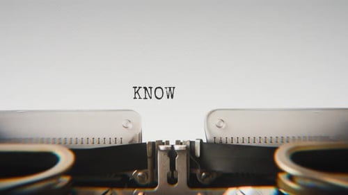Old mechanical typewriter typing Knowledge in a close-up view.