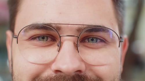 Closeup Macro Portrait of Natural Young Attractive Man in Glasses with Gray Eyes Looking at Camera