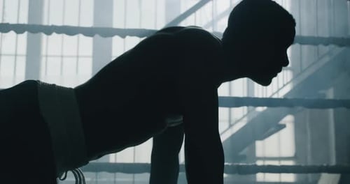 Cinematic shot of a professional young muscular shirtless african man is practicing shadow boxing